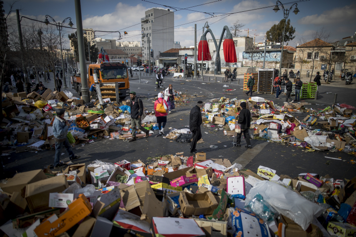 People walk past piles of garbage caused by a strike of the Jerusalem municipality, at the Mahane Yehuda Market in Jerusalem, on January 30, 2017. Photo by Yonatan Sindel/Flash90 *** Local Caption *** ?????
??????
???
?????
???????
??? ???? ?????