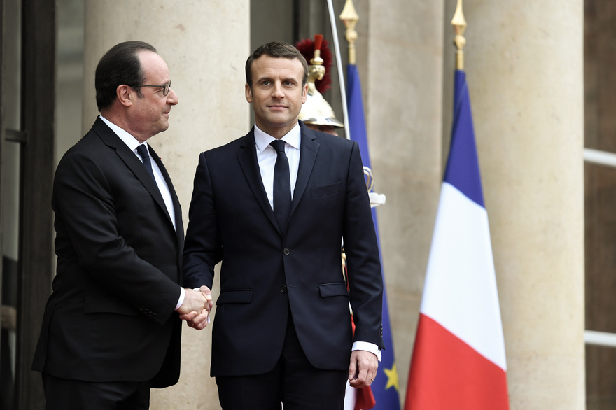 French newly elected President Emmanuel Macron (R) is welcomed by his predecessor Francois Hollande as he arrives at the Elysee presidential Palace for the handover and inauguration ceremonies on May 14, 2017 in Paris. / AFP PHOTO / STEPHANE DE SAKUTIN
