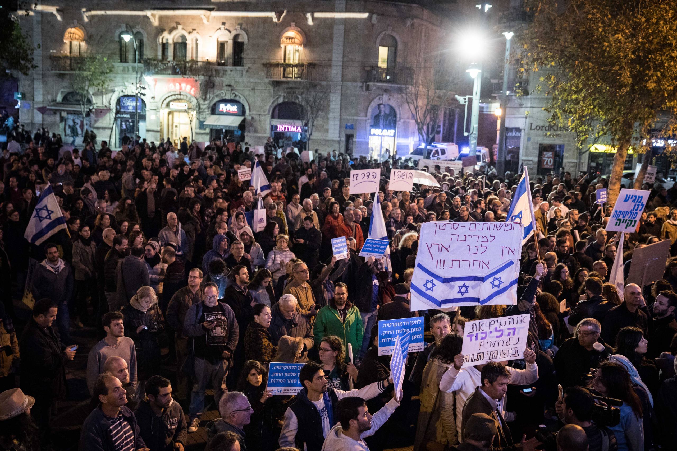 Israelis hold signs and shout slogans during a rally against the corruption of the government at Zion Square in Jerusalem on December 23, 2017. Photo by Hadas Parush/Flash90 *** Local Caption *** äôâðä
îôâéðéí
ääôâðä äùáåòéú ðâã ùçéúåú ùìèåðéú
éøåùìéí
ëéëø öéåï