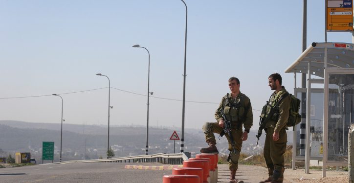 Israeli soldiers seen patrolling at a bus stop, near the spot at the entrance to the West Bank settlement of Alon Shvut where a Palestinian man last night rammed his car into, stabbing and killing a young Jewish woman, and injuring two more. November 11, 2014.  Photo by Nati Shohat/Flash90


 *** Local Caption *** ????? 
????
??? ?????
?????
????
????????
??????