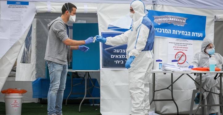 People arrive to vote at a special polling station for voters quarantined due to possible exposure to the new coronavirus in Jerusalem, during the Knesset Elections, on March 2, 2020. Photo by Nati Shohat/Flash90 *** Local Caption *** ?????
??????
????
???
???????
??????
??????
????? ?