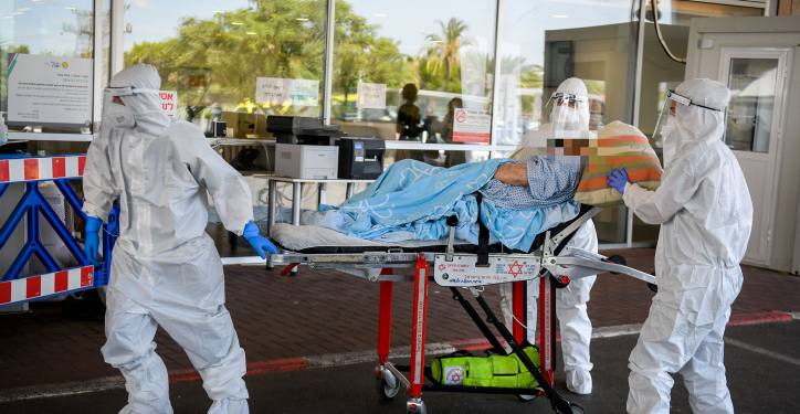 Magen David Adom workers wearing protective clothing evacuate a patient with suspicion to coronavirus outside the coronavirus unit at the Sheba Medical Center in Ramat Gan on July 8, 2020. Photo by Flash90 *** Local Caption *** ??????
??? ?????
????
?????
????

?????