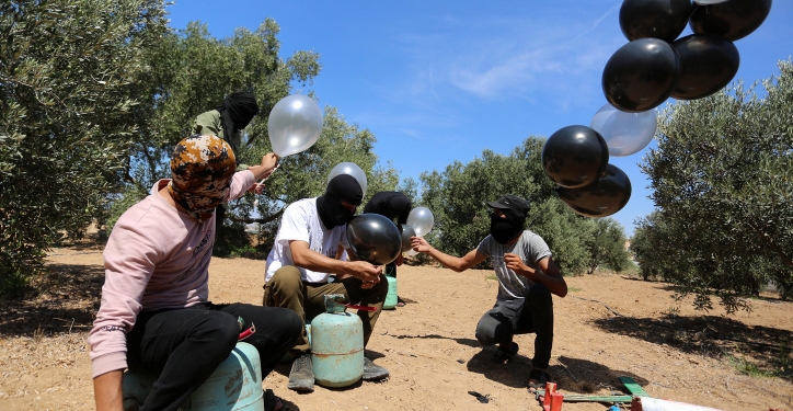 Palestinian men prepare a flammable object to be flown toward Israel, near the Israel-Gaza border, in the eastern part of the Gaza Strip, August 10, 2020. Photo by Abed Rahim Khatib/Flash90 *** Local Caption *** ????????
????? ???
????
?????
??????
????? ?????