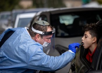 Health care workers take test samples of Israelis in a drive through complex to check if they have been infected with the Coronavirus in Jerusalem, on December 21, 2021. Photo by Yonatan Sindel/Flash90 *** Local Caption *** ????? ??????  
???????
??? ??????
?????
???
????? ?????
????????