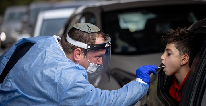Health care workers take test samples of Israelis in a drive through complex to check if they have been infected with the Coronavirus in Jerusalem, on December 21, 2021. Photo by Yonatan Sindel/Flash90 *** Local Caption *** ????? ??????  
???????
??? ??????
?????
???
????? ?????
????????
