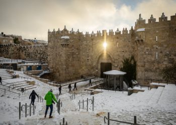 People walk at Damascus Gate covered in snow, in Jerusalem's Old City, as a heavy storm hits nationwide, January 27, 2022. Photo by Yonatan Sindel/Flash90 *** Local Caption *** ??? ???
??? ????
????
???
???