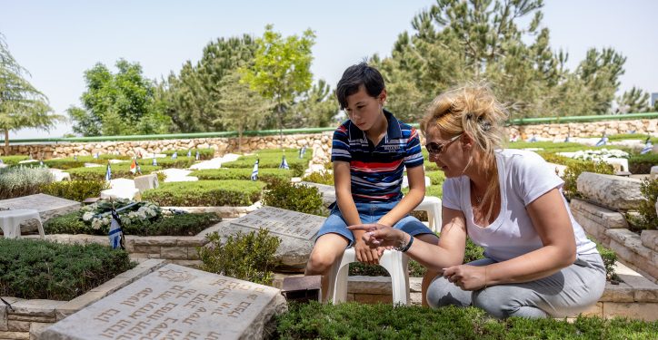 Family members at the grave of a loved one in Mount Herzl Military Cemetery in Jerusalem, on May 3, 2022, ahead of Israeli Memorial Day, which begins tonight. Photo by Yonatan Sindel/Flash90 *** Local Caption *** ?????
???????
????
??????
?? ????
??? ???????
???? ???
??? ??????